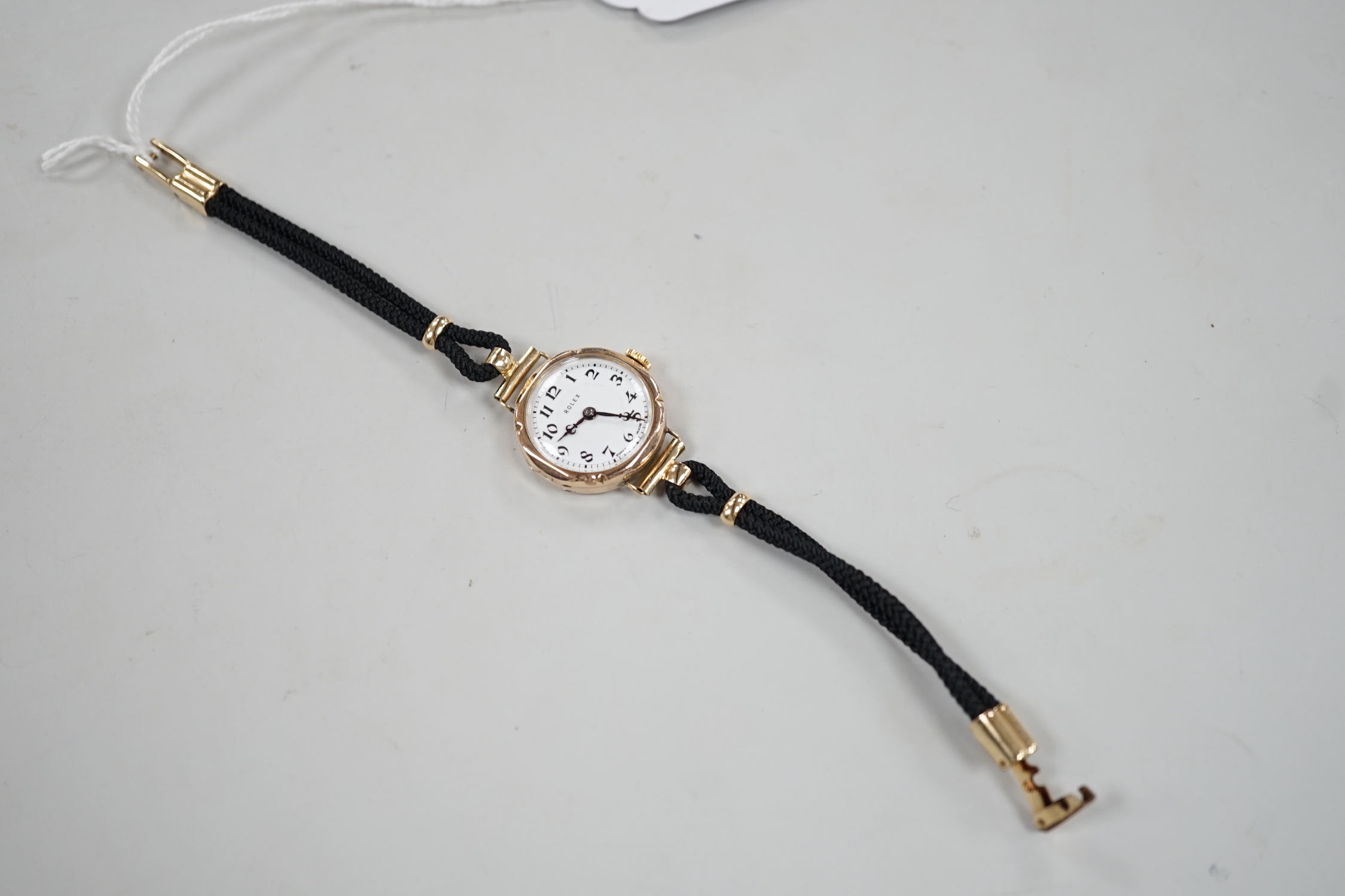 A lady's 1920's 9ct gold Rolex manual wind wrist watch, on associated fabric strap.